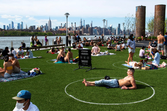 뉴욕 시민들이 16일(현지시간) 브루클린 도미노파크에서 코로나19 확산을 막기위해 사회적 거리를 유지하며 오후 햇살을 즐기고 있다. 로이터 연합뉴스