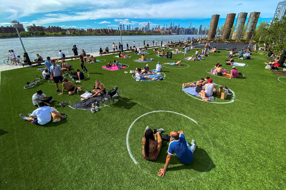 뉴욕 시민들이 16일(현지시간) 브루클린 도미노파크에서 코로나19 확산을 막기위해 사회적 거리를 유지하며 오후 햇살을 즐기고 있다. 로이터 연합뉴스