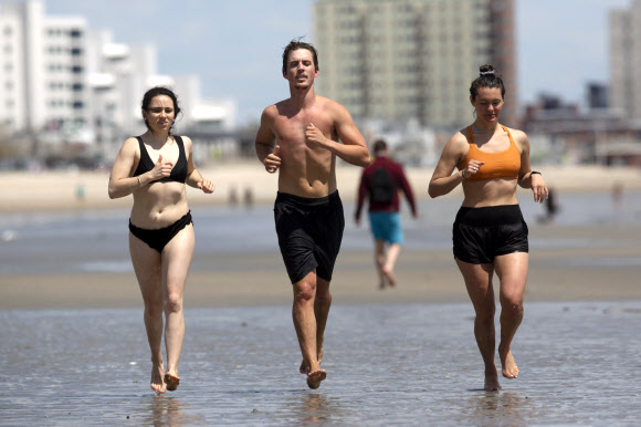 16일(현지시간) 미국 매사추세츠 리비어 비치에서 시민들이 조깅을 즐기고 있다. AP 연합뉴스