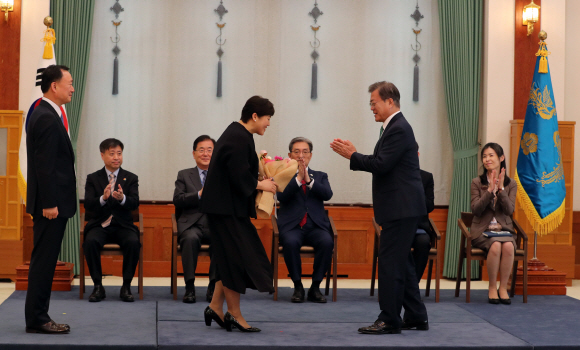 문재인 대통령이 19일 오후 청와대에서 유연상 신임 경호처장에게 임명장을 수여한 뒤 부인 안현미 씨에게 꽃다발을 주고 있다.유연상 신임 경호처장은 대통령 경호실이 공개채용을 시작한 1988년 이후 공채 출신으로는 처음으로 경호처장까지 올랐다. 2020. 5. 19 도준석 기자pado@seoul.co.kr
