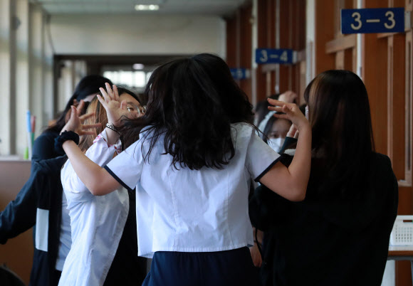 고등학교 3학년 등교 개학 첫날인 20일 오전 부산 동래구 중앙여자고등학교에서 쉬는시간 학생들이 친구와 반갑게 인사하고 있다. 2020.5.20  연합뉴스