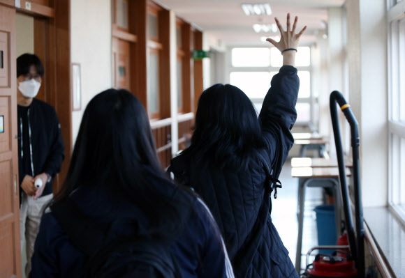 20일 오전 대구시 중구 경북여자고등학교에서 신종 코로나바이러스 감염증(코로나19)으로 개학이 80일 미뤄졌다가 이날 등교한 고3 학생이 선생님에게 손을 들어 인사하고 있다. 2020.5.20  연합뉴스