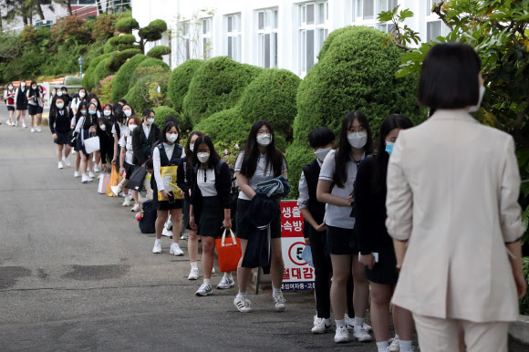 20일 오전 올해 첫 교실 수업을 하는 광주 남구 한 여자고등학교에서 고3 학생이 건강 상태를 확인을 위한 차례를 기다리고 있다. 2020.5.20  연합뉴스