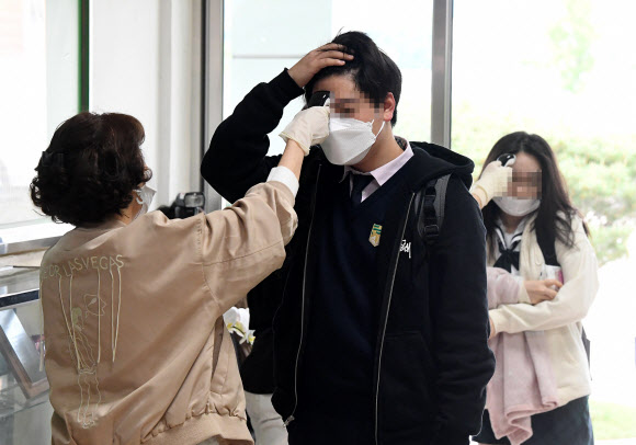 고등학교 3학년 학생들의 등교 개학이 시작된 20일 오전 서울의 한 고등학교에서 학생들이 등교하며 발열 검사를 받고 있다. 2020.5.20  연합뉴스