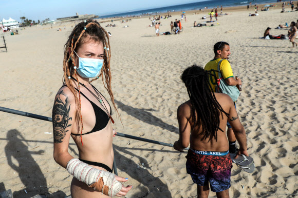 19일(현지시간) 포르투갈 리스본 인근 오에이라스에서 시민들이 카르카벨로스 해변에서 일광욕을 즐기고 있다. EPA 연합뉴스