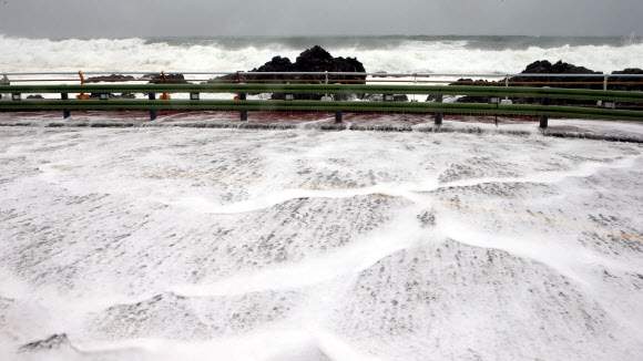 20일 강원 강릉시의 한 해안도로로 너울에 의해 넘어온 바닷물이 하얗게 흐르고 있다. 기상청은 동해 중부 해상에 풍랑경보가 발효되면서 오는 21일까지 물결이 3∼6?로 매우 높게 일겠다며 주의를 당부했다. 2020.5.20  연합뉴스