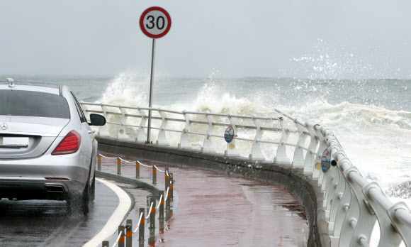 20일 너울성 파도가 높게 치는 강원 강릉시의 한 해안도로에서 차량이 서행하고 있다. 기상청은 동해 중부 해상에 풍랑경보가 발효되면서 오는 21일까지 물결이 3∼6?로 매우 높게 일겠다며 주의를 당부했다. 2020.5.20 연합뉴스