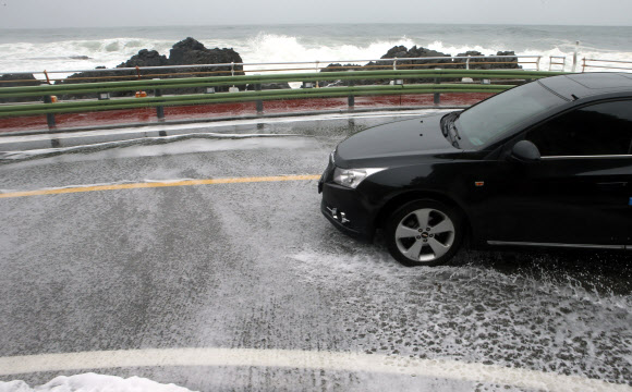 20일 너울성 파도가 높게 치는 강원 강릉시의 한 해안도로에서 차량이 서행하고 있다. 기상청은 동해 중부 해상에 풍랑경보가 발효되면서 오는 21일까지 물결이 3∼6?로 매우 높게 일겠다며 주의를 당부했다. 2020.5.20 연합뉴스