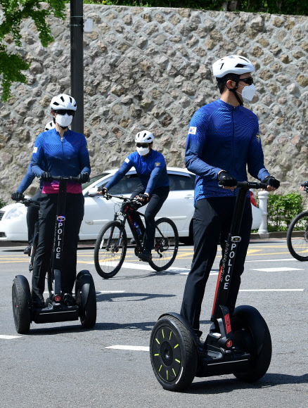 청와대 외곽 경비를 담당하고 있는 202 경비단 소속 경찰들이 20일 전동휠과 자전거를 타고서 청와대 인근에서 순찰 활동을 하고 있다.  청와대 경호처는 ‘친근한 경호’, ‘열린 경호’, ‘낮은 경호’ 방침을 구현하기 위해 시민들에게 친근함을 주는 자전거 순찰대를 운영해오고 있다. 2020.5.20  연합뉴스