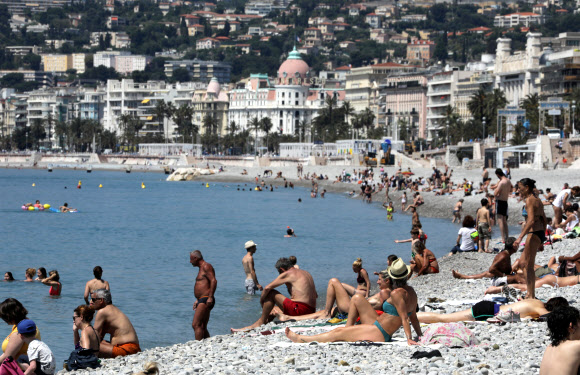 사람들이 21일(현지시간) 프랑스 니스에서 코로나19가 발생한 후 엄격한 폐쇄 규칙을 완화하면서 해변을 다시 개방한 후, 프로메나데 데 앙글라이스 해변에서 일광욕을 하고 있다. 로이터 연합뉴스