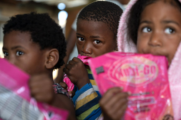 남아프리카공화국 케이프타운의 7de Laan 비공인 정착촌의 어린이들이 21일(현지시간) 나인 마일스 프로젝트(9 Miles Project)로 제공된 아침 식사를 들고 있다. 케이프타운 EPA 연합뉴스 