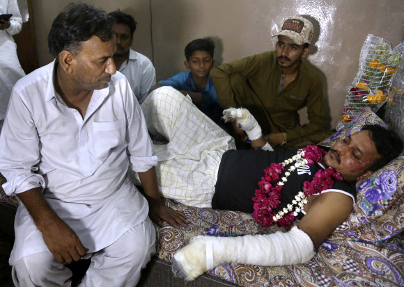 파키스탄 카라치에 추락한 여객기에서 극적으로 살아남은 무함마드 주바이르(오른쪽)가 23일(현지시간) 카라치 자택에서 문병 온 친척들과 이야기를 나누고 있다. 카라치 AP 연합뉴스