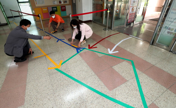 초등학생 등교 동선 안내 표시하는 교사들