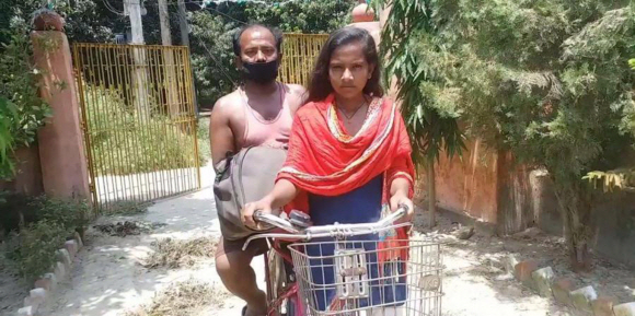 15세 인도 소녀 조티 쿠마리가 다친 아버지를 자전거 뒤에 태운 채 거리를 지나고 있다. 뉴인디언익스프레스 캡처