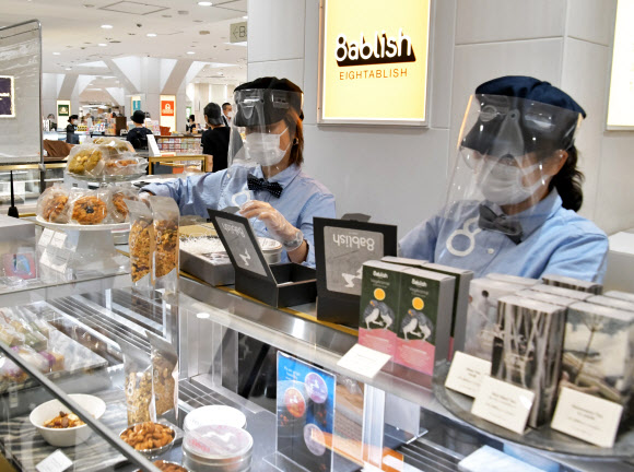 지난 25일 일본 도쿄의 한 대형 백화점에서는 직원들이 마스크와 페이스 쉴드를 착용하고 상품을 판매하고 있다. UPI 연합뉴스