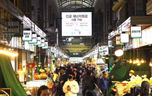 코로나19 사태로 얼어붙었던 소비심리가 이달부터 점차 회복되고 있는 가운데 26일 서울 마포구 망원시장이 장을 보러 나온 시민들로 북적이고 있다. 시장 중앙 전광판에 ‘긴급재난지원금 사용 가능’이라고 표시돼 있다. 오장환 기자 5zzang@seoul.co.kr