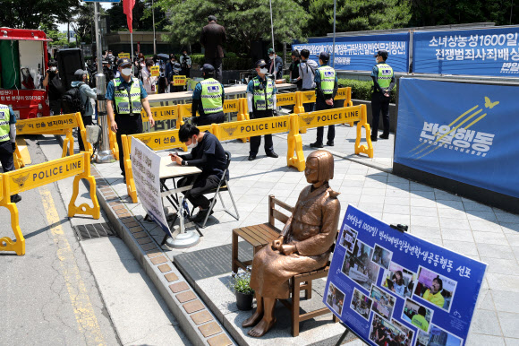 대한민국애국시민연합 회원들이 28일 오후 서울 종로구 옛 일본대사관 앞 설치된 소녀상 뒤로 ‘정의기억연대 해체 및 윤미향 당선인 규탄 집회’를 하고 있다. 2020.5.28  연합뉴스