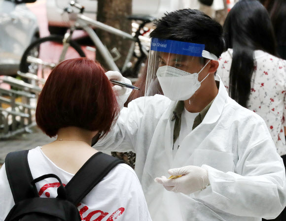 경기도 부천 쿠팡 물류센터와 연관된 신종 코로나바이러스 감염증(코로나19) 확진자가 속출한 28일 오후 경기도 부천시 중동 부천시보건소 선별진료소에서 진료소 관계자가 검사를 기다리는 시민의 발열 상태를 점검하고 있다. 2020.5.28  연합뉴스