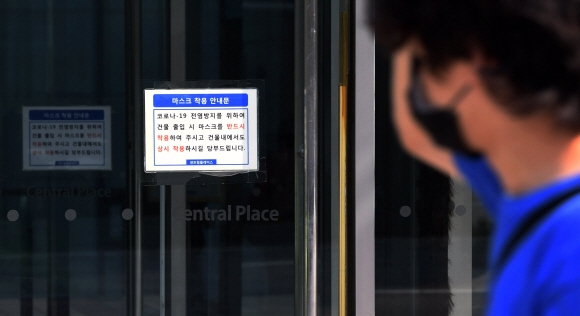 28일 서울 중구 서소문로 센트럴플레이스 출입구에 코로나 19 전염 방지를 위한 마스크 착용 안내문이 붙어 있다. 전날 이 건물 7층에 위치한 KB생명 영업지점에서 직원 1명이 코로나19 확진 판정을 받으면서 직장 동료 약 100명이 격리되고 빌딩 해당 층이 폐쇄됐다. 2020.5.28 오장환 기자 5zzang@seoul.co.kr