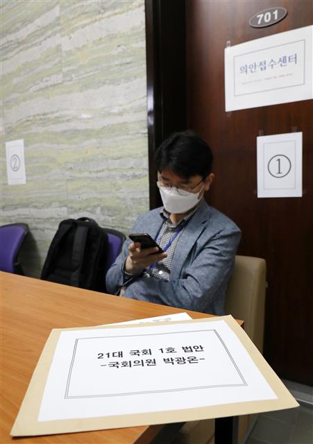 29일 오전 서울 여의도 국회 의안과 앞에 더불어민주당 박광온 의원실 보좌관이 1호 법안을 접수하기위해 대기하고 있다.  21대 국회 개원을 앞두고 상징적인 1호 법안을 제출하기 위한 줄서기가 시작됐다. 21대 국회 의안 접수는 휴일을 지나 6월 1일 오전9시에 개시한다. 2020.5.29 뉴스1