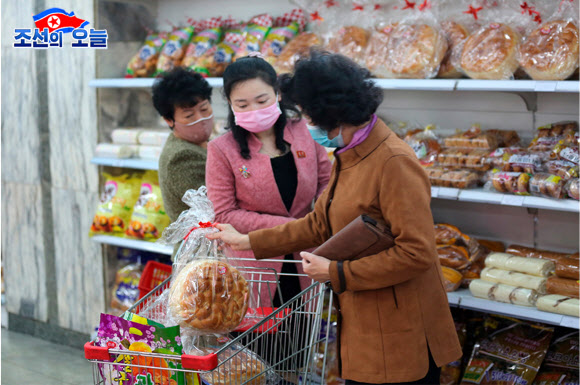 북한 대외선전매체 ‘조선의 오늘’은 29일 쇼핑객들로 붐비는 평양 제1백화점의 모습을 공개했다. 1층 식료품매대와 2층 가방매대 등에서 마스크를 쓴 채 물건을 살피고 고르는 사람들의 모습이 사진에 담겼다. 2020.5.29.  조선의 오늘 캡처