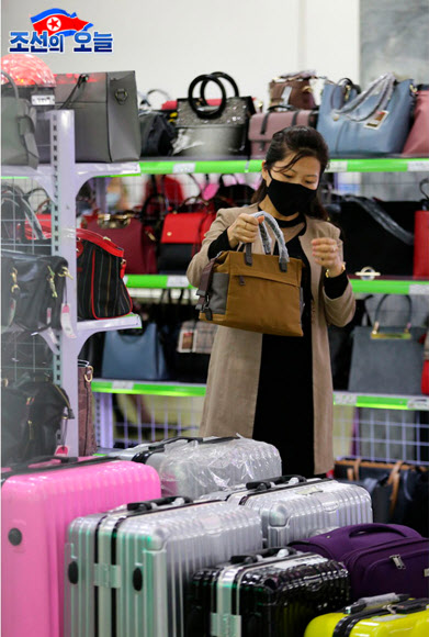 북한 대외선전매체 ‘조선의 오늘’은 29일 쇼핑객들로 붐비는 평양 제1백화점의 모습을 공개했다. 1층 식료품매대와 2층 가방매대 등에서 마스크를 쓴 채 물건을 살피고 고르는 사람들의 모습이 사진에 담겼다. 2020.5.29.  조선의 오늘 캡처