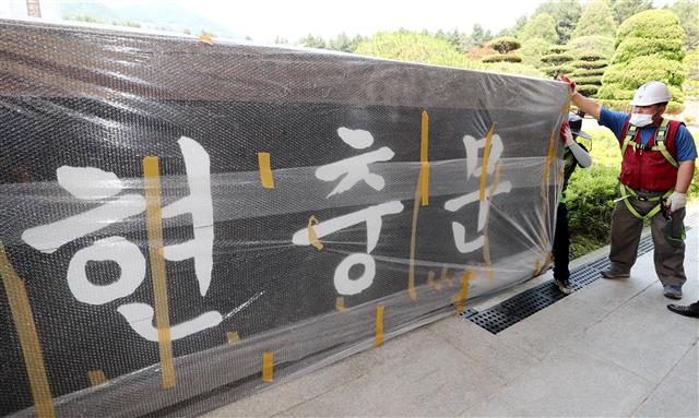 29일 오후 대전 유성구 국립대전현충원에서 관계자들이 기존에 걸려있던 현충문 현판을 옮기고 있다. 국가보훈처는 국립대전현충원 현충문에 걸린 전두환 전 대통령 친필 현판을 안중근체로 교체한다. 2020.5.29 뉴스1