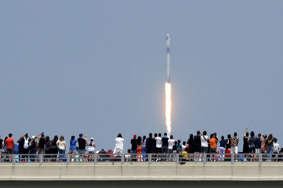 30일(현지시간) 미국 항공우주국(NASA) 소속 우주비행사 2명을 태운 미국의 첫 민간 유인우주선이 발사된 가운데 시민들이 우주선 발사 모습을 지켜보고 있다. 이날 쏘아 올려진 우주선은 테슬라 최고경영자(CE0) 일론 머스크가 설립한 스페이스X가 개발한 유인 우주선 ‘크루 드래건’이다. AP 연합뉴스