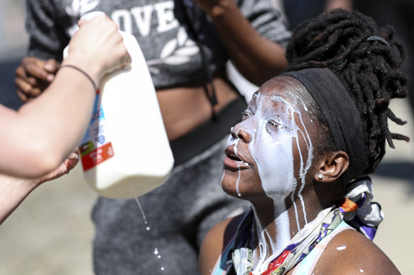 미네소타주 미니애폴리스에서 지난 25일(이하 현지시간) 일어난 백인 경찰이 흑인인 조지 플로이드의 목을 무릎으로 눌러 숨진 사건에서 비롯된 시위가 30일 워싱턴DC와 캘리포니아, 뉴욕 등 22개 주 30개 이상의 도시에서 벌어지고 있는 가운데 최루 가스에 노출된 시민들이 우유로 눈을 씻어내고 있다. AP 연합뉴스