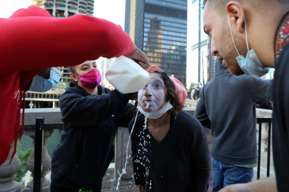 미네소타주 미니애폴리스에서 지난 25일(이하 현지시간) 일어난 백인 경찰이 흑인인 조지 플로이드의 목을 무릎으로 눌러 숨진 사건에서 비롯된 시위가 30일 워싱턴DC와 캘리포니아, 뉴욕 등 22개 주 30개 이상의 도시에서 벌어지고 있는 가운데 최루 가스에 노출된 시민들이 우유로 눈을 씻어내고 있다. AP 연합뉴스