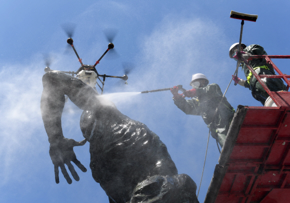 1일 서울 송파구 올림픽로에서 구청 관계자들이 드론과 고압 세척기를 이용해 올림픽 상징 조형물을 세척하고 있다. 2020. 6. 1  이종원 선임기자 jongwon@seoul.co.kr