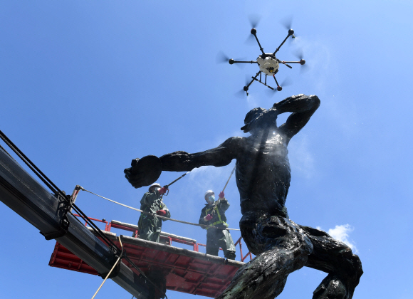 1일 서울 송파구 올림픽로에서 구청 관계자들이 드론과 고압 세척기를 이용해 올림픽 상징 조형물을 세척하고 있다. 2020. 6. 1  이종원 선임기자 jongwon@seoul.co.kr