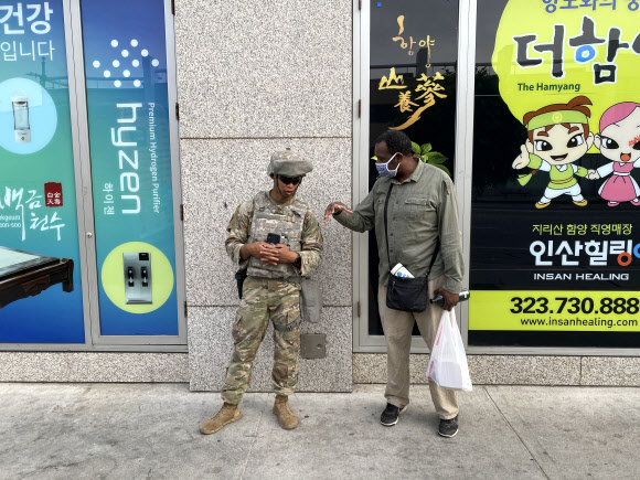 LA 한인타운 앞에서 대화를 나누는 중년의 흑인 남성과 주방위군 병사