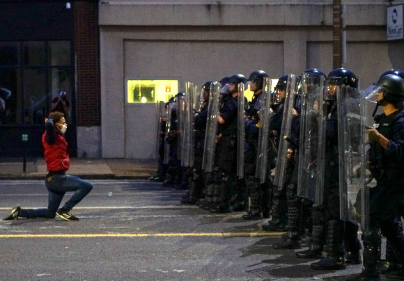 1일(현지시간) 미국 미네소타주 미니애폴리스에서 한 남성이 경찰들 앞에서 무릎을 꿇고 있다. 로이터 연합뉴스