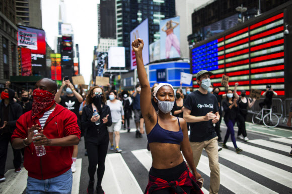 흑인 남성 조지 플로이드가 백인 경찰의 과잉 진압으로 숨진 이후 인종차별 규탄 시위가 미국 전역으로 확산되고 있는 가운데 2일(현지시간) 뉴욕 타임스 스퀘어에서 시위대가 거리행진을 하고 있다. AP 연합뉴스