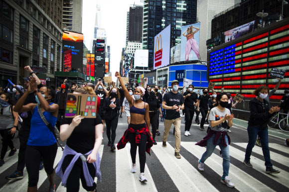 흑인 남성 조지 플로이드가 백인 경찰의 과잉 진압으로 숨진 이후 인종차별 규탄 시위가 미국 전역으로 확산되고 있는 가운데 2일(현지시간) 뉴욕 타임스 스퀘어에서 시위대가 거리행진을 하고 있다. AP 연합뉴스