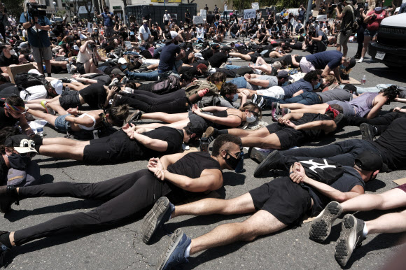 LGBT 커뮤니티 회원들이 3일(현지시간) 미국 캘리포니아 웨스트 할리우드에서 플로이드의 죽음에 항의해 교차로를 봉쇄하면서 ‘흑인의 생명도 소중하다(Black lives matter)’시위와 행진 중에 die-in(죽은 것처럼 드러눕는 시위 행동)에 참여하고 있다. AP 연합뉴스