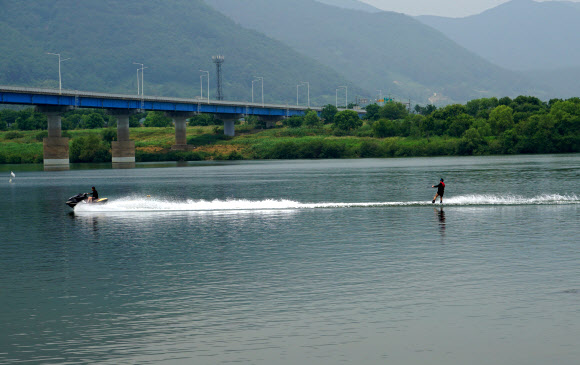 현충일인 6일 시민들이 무더위를 피해 경남 창원시 동읍 본포수변생태공원을 찾아 낙동강에서 수상스키를 즐기며 더위를 식히고 있다. 2020.6.6  연합뉴스