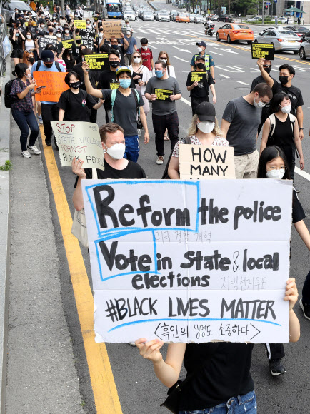 6일 오후 서울 명동에서 열린 ‘조지 플로이드’ 사건 추모 행진 집회에서 참가자들이 손피켓을 들고 행진하고 있다. 2020.6.6  연합뉴스