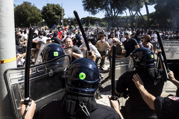 네오 파시스트 단체들, 이탈리아 프로축구 구단의 극성 서포터들이 6일(현지시간) 로마의 서커스 막시무스에서 정부의 코로나19 대응에 항의하는 집회를 갖던 중 경찰관들과 대치하고 있다. 로마 EPA 연합뉴스 