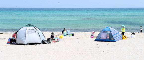 맑은 날씨를 보인 7일 오전 제주시 함덕해수욕장에서 도민과 관광객들이 생활 속 거리두기를 실천하며 여유롭게 주말을 보내고 있다. 2020.6.7  연합뉴스