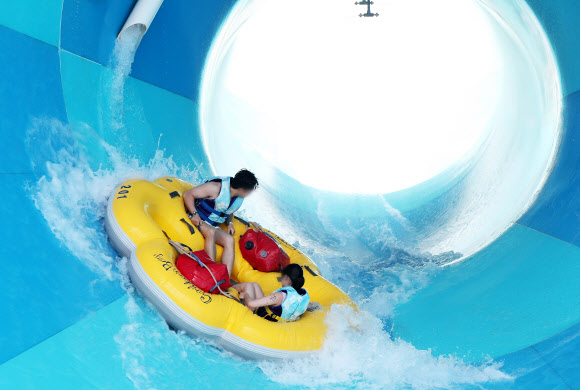 무더운 날씨를 보인 7일 오후 경기도 용인시 에버랜드 캐리비안 베이를 찾은 시민들이 신종 코로나바이러스 감염증(코로나19) 예방을 위한 거리 두기를 지키며 워터 슬라이드를 즐기고 있다. 2020.6.7  연합뉴스