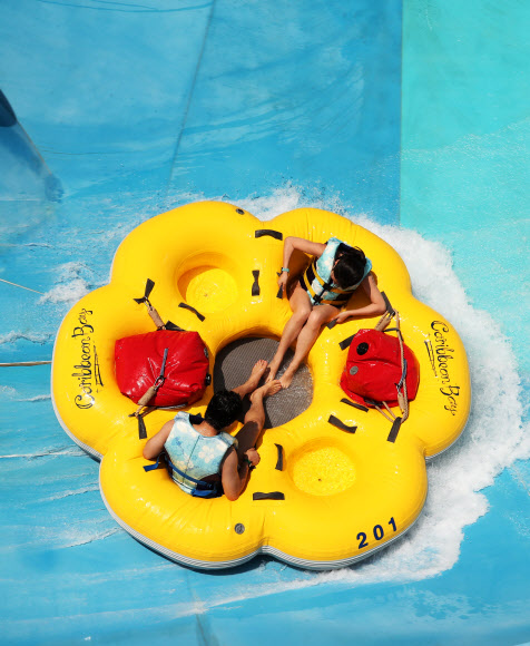 무더운 날씨를 보인 7일 오후 경기도 용인시 에버랜드 캐리비안 베이를 찾은 시민들이 신종 코로나바이러스 감염증(코로나19) 예방을 위한 거리 두기를 지키며 워터 슬라이드를 즐기고 있다. 2020.6.7  연합뉴스