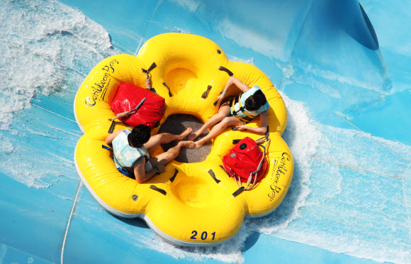 무더운 날씨를 보인 7일 오후 경기도 용인시 에버랜드 캐리비안 베이를 찾은 시민들이 신종 코로나바이러스 감염증(코로나19) 예방을 위한 거리 두기를 지키며 워터 슬라이드를 즐기고 있다. 2020.6.7  연합뉴스