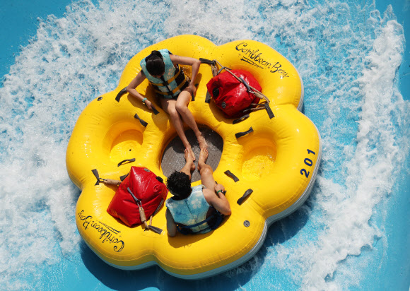 무더운 날씨를 보인 7일 오후 경기도 용인시 에버랜드 캐리비안 베이를 찾은 시민들이 신종 코로나바이러스 감염증(코로나19) 예방을 위한 거리 두기를 지키며 워터 슬라이드를 즐기고 있다. 2020.6.7  연합뉴스