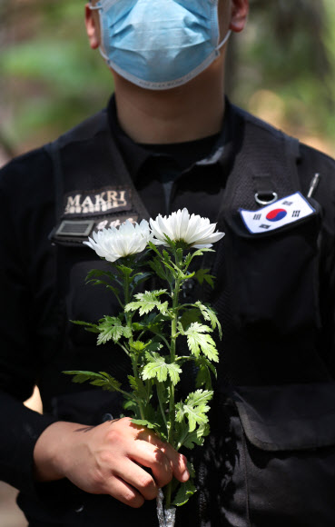 8일 오후 강원 화천군 하남면 서오지리 내 6·25 전사자 유해발굴 현장에서 국방부 관계자들이 국화를 들고 있다. 2020.6.8  연합뉴스