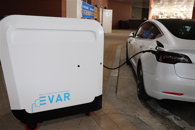 이동식 전기차 충전기인 ‘에바’를 쇼핑카트처럼 끌고 와 충전 단자를 차량에 연결해 전기를 공급하고 있다.  이종원 선임기자 jongwon@seoul.co.kr