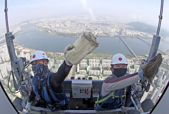 9일 서울 송파구 롯데월드타워 120층에서 전문 작업자들이 외벽 유리창을 청소하고 있다.  롯데월드타워 123개 층 약 4만2천여 장의 유리창을 청소하는 데는 약 700시간이 걸릴 것으로 예상한다. 하루 8시간 작업하는 것으로 가정해 날수로 환산하면 약 90일이 걸리는 대규모 청소 작업이다. 2020.6.9  연합뉴스