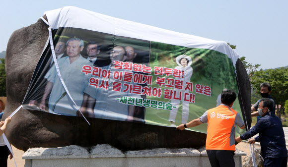 일해공원 표지석을 대형 현수막으로 덮고 있는 시민단체. 연합뉴스  
