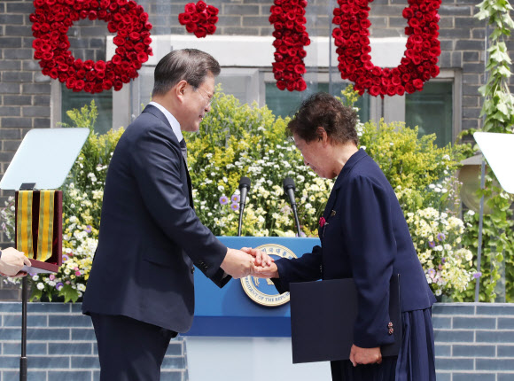문재인 대통령이 10일 오전 서울 용산구 민주인권기념관에서 열린 6·10 민주항쟁 기념식에서 고(故) 이한열 열사 모친 배은심 씨에게 국민훈장 모란장을 수여하고 있다. 2020.6.10  연합뉴스